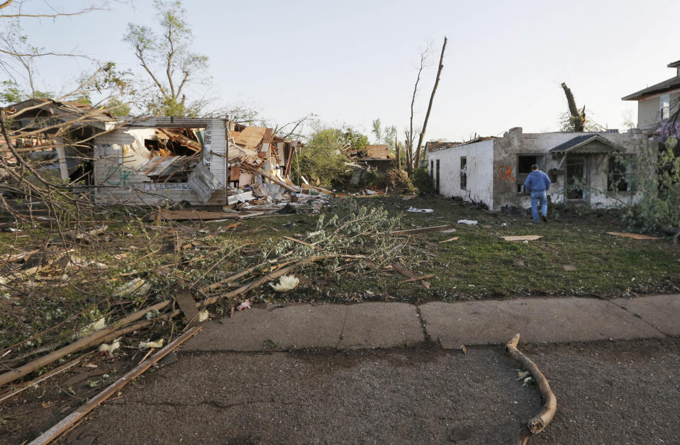 Bob Hessee checks out property owned by a friend and damaged by a tornado in Baxter Springs, Kan., Monday, April 28, 2014. A tornado damaged dozens of buildings and injured at least 25 people on Sunday. (AP Photo/Orlin Wagner)