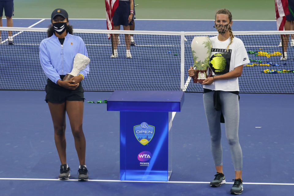 Victoria Azarenka, of Belarus, right, holds her winners trophy, as she celebrates winning the Western & Southern Open tennis tournament along with her opponent, Naomi Osaka, of Japan, left, during a trophy ceremony Saturday, Aug. 29, 2020, in New York. Azarenka won the tournament after her finals opponent, Naomi Osaka, of Japan, withdrew because of a hamstring injury. (AP Photo/Frank Franklin II)
