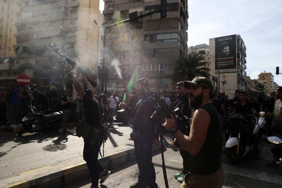 Supporters of the Shiite Amal group fire weapons in the air during the funeral processions of Hassan Jamil Nehmeh, who was killed during yesterday clashes, in the southern Beirut suburb of Dahiyeh, Lebanon, Friday, Oct. 15, 2021. Dozens of gunmen opened fire in the air Friday south of Beirut during the funeral of persons killed in hours of gun battles between heavily armed gunmen the day before that left several people dead and terrorized the residents of Beirut. (AP Photo/Bilal Hussein)