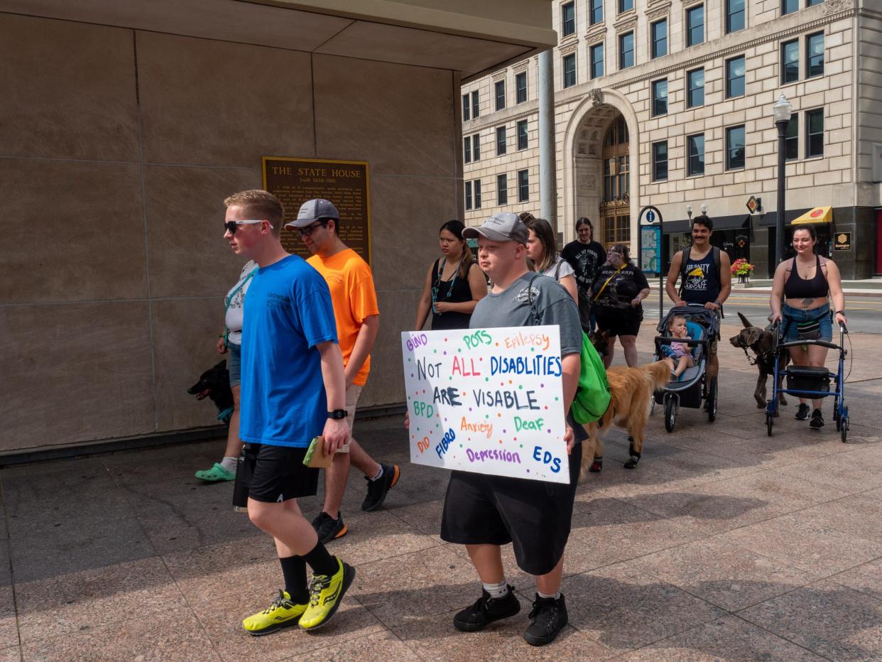 Protestors marched around the Ohio Statehouse Saturday, stopping a few times to chant together and share stories. Most protestors had service animals or signs with them.