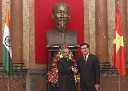 India's President Pranab Mukherjee (L) poses for a photo with his Vietnamese counterpart Truong Tan Sang under a statue of late Vietnamese revolutionary leader Ho Chi Minh before their meeting at the Presidential Palace in Hanoi September 15, 2014. REUTERS/Kham