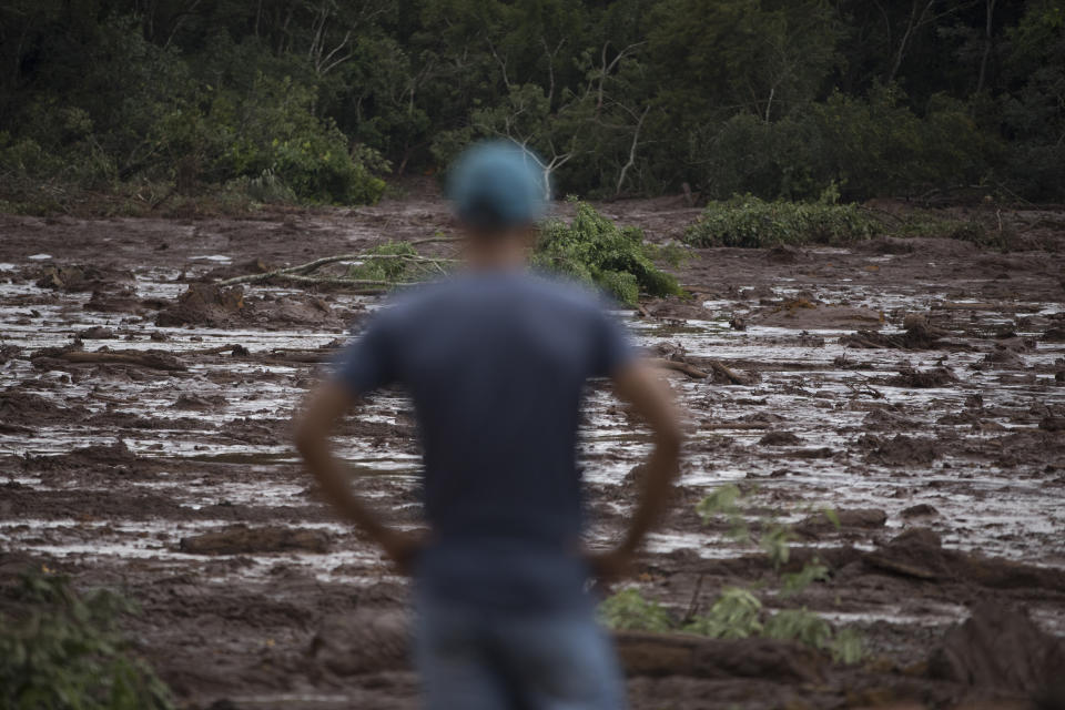 A man looks at the mud after a dam collapse near Brumadinho, Brazil, Saturday, Jan. 26, 2019. Rescuers in helicopters searched for survivors while firefighters dug through mud in a huge area in southeastern Brazil buried by the collapse of a dam holding back mine waste, with at least nine people dead and up to 300 missing. (AP Photo/Leo Correa)