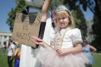 <p>Im kalifornischen Berkeley treten eine Mutter und ihre vier Jahre alte Tochter als Prinzessinnen verkleidet auf einer Demonstration auf. Gemeinsam setzen sie sich gegen Nazis ein, wie dem Schild zu entnehmen ist, das die Mutter hält. (Bild: Elijah Nouvelage/Getty Images) </p>