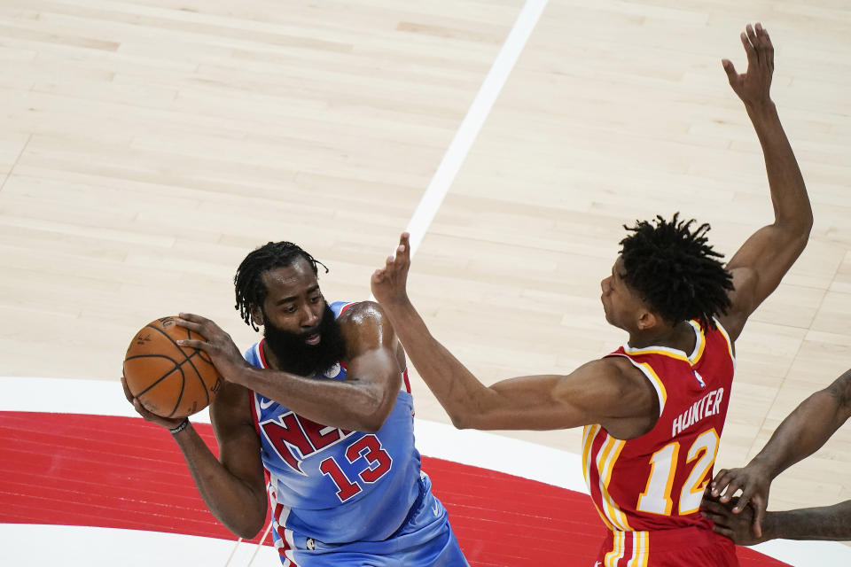 Brooklyn Nets' James Harden (13) is defended Atlanta Hawks' De'Andre Hunter (12) during the first half of an NBA basketball game Wednesday, Jan. 27, 2021, in Atlanta. (AP Photo/Brynn Anderson)