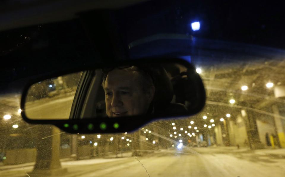 Doctor Patrick Angelo is reflected in his mirror as he drives around looking for homeless people under the overpasses on Lower Wacker Drive in Chicago, Illinois, January 7, 2014. Angelo visits the homeless several times a week to hand out food, clothing and blankets to those living on the streets with funding coming from his oral surgery practice and profits from his healthcare company. Angelo is in his 13th year doing charity work. Picture taken January 7, 2014. REUTERS/Jim Young (UNITED STATES - Tags: SOCIETY POVERTY)