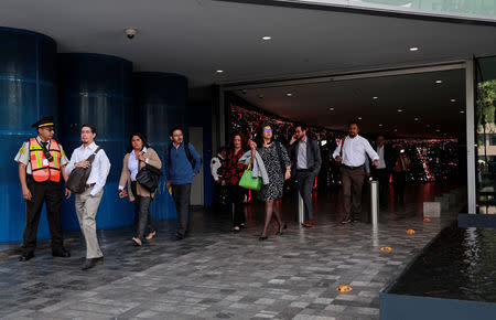 People are evacuated from the Mexican headquarters of Spain's BBVA due to what the bank said were two anonymous emails threatening violent acts against its corporate offices, in Mexico City, Mexico March 13, 2019. REUTERS/Henry Romero