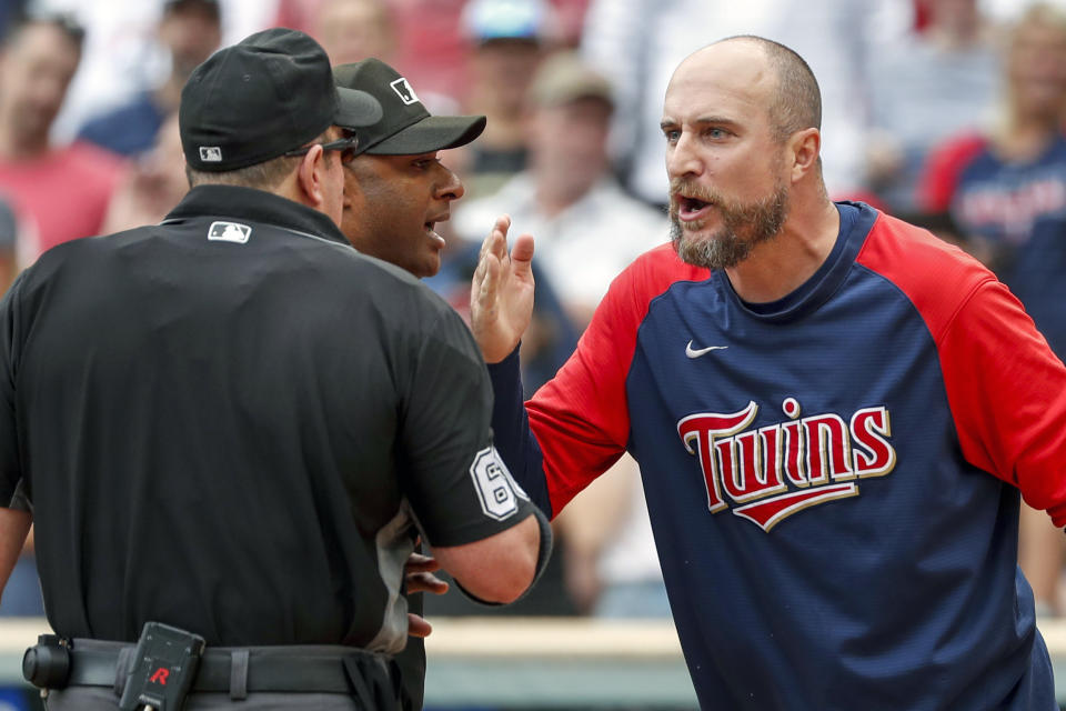 Minnesota Twins manager Rocco Baldelli, right, argues with umpires Marty Foster, left, and Alan Porter after a review reversed a call that originally had Toronto Blue Jays' Whit Merrifield out at home in the 10th inning of a baseball game Sunday, Aug. 7, 2022, in Minneapolis. The Blue Jays won 3-2 in 10 innings. (AP Photo/Bruce Kluckhohn)