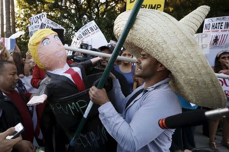 A man protests with a Donald Trump pinata in a trash can outside the Luxe Hotel, where Republican presidential candidate Donald Trump was expected to speak in Brentwood, Los Angeles, California, United States July 10, 2015. REUTERS/Lucy Nicholson