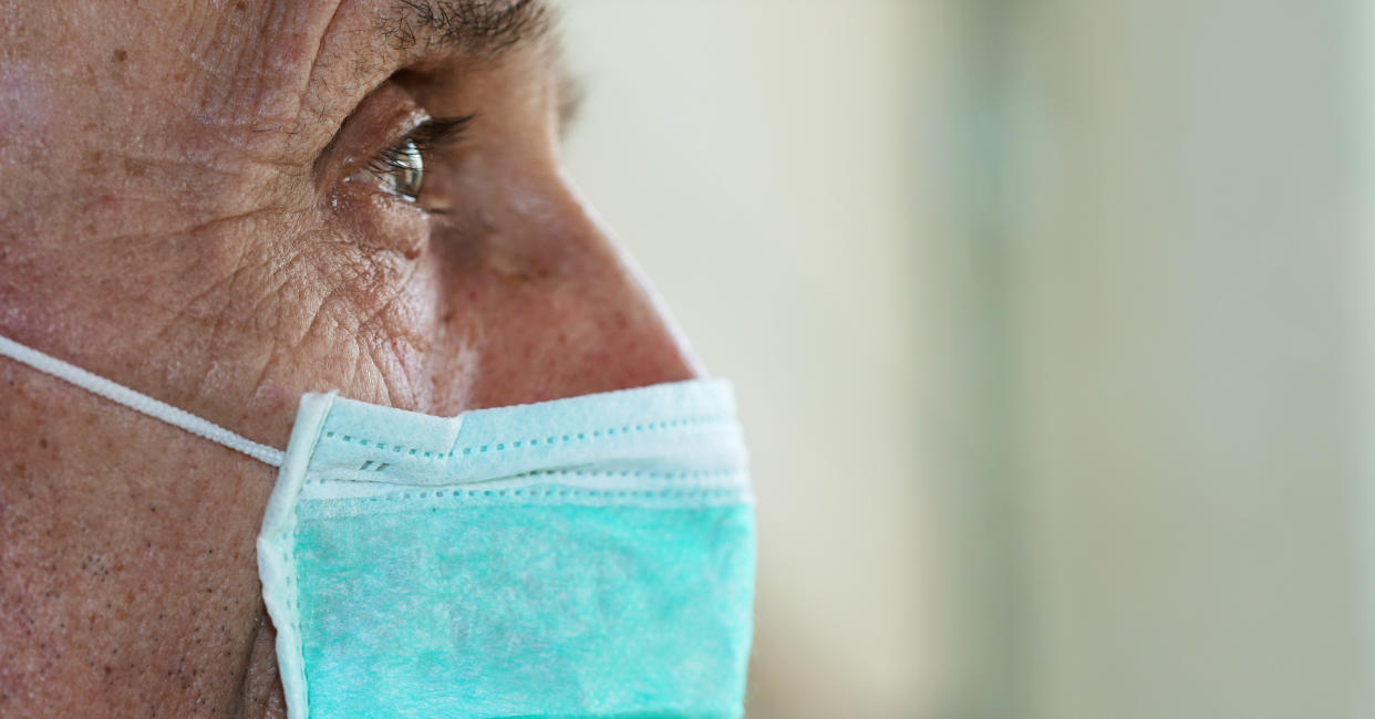 face of elderly man wearing medical facemask health safety concept