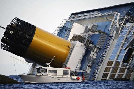 Rescuers wait on a boat near the Costa Concordia. Costa Crociere, the owner of the luxury liner that ran aground off the coast of Italy, killing at least five people, said on Sunday its captain had made "errors of judgment"