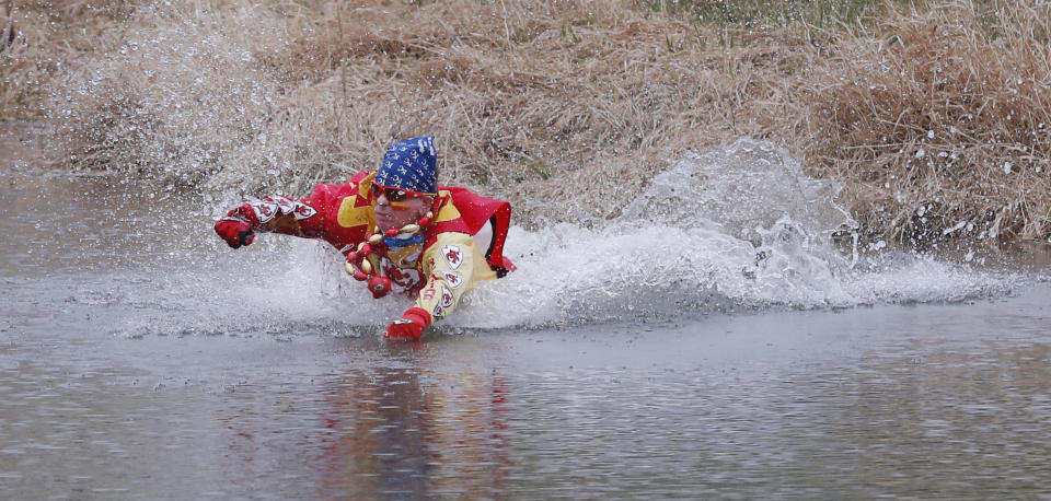 Kansas City Chiefs fan Ty Rowton, known as XFactor, takes a Plunge for Landon in a farm pond near Bonner Springs, Kan., Friday, April 4, 2014. A 5-month-old boy's battle with cancer has inspired hundreds to jump into cold bodies of water, from a local golf course pond to the Gulf of Mexico and even the Potomac River in Washington, D.C. (AP Photo/Orlin Wagner)