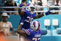 Buffalo Bills running back Devin Singletary (26) is lifted by Buffalo Bills offensive tackle Dion Dawkins (73) after scoring a touchdown during the first half of an NFL football game, Sunday, Sept. 19, 2021, in Miami Gardens, Fla. (AP Photo/Wilfredo Lee)