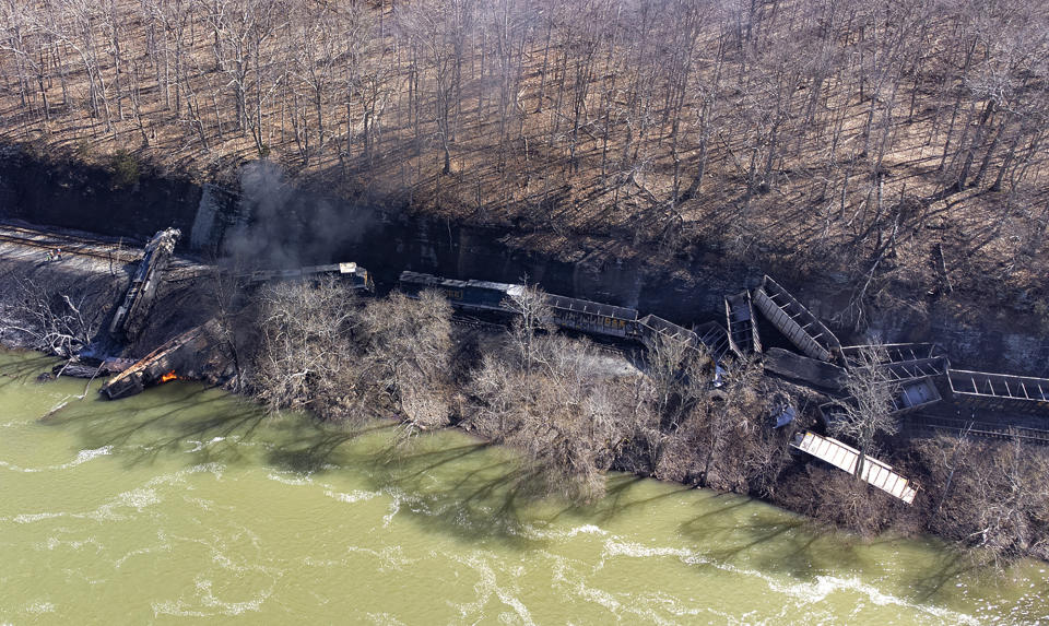 Smoke fills the sky after an empty CSX coal train hit a rockslide along tracks causing a fiery derailment on Wednesday, March 8, 2023 in a remote area just south of Sandstone, W.Va. Four locomotives and 22 empty cars derailed in Summers County near the New River, CSX said. The lead locomotive, which carried a conductor, an engineer and an engineer trainee, caught fire and the crewmembers were being evaluated and treated for non-life threatening injuries, the company said. (Jenny Harnish/The Register-Herald via AP)