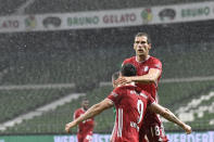 Bayern's Robert Lewandowski celebrates with his teammate Bayern's Leon Goretzka after scoring his side's opening goal during the German Bundesliga soccer match between Werder Bremen and Bayern Munich in Bremen, Germany, Tuesday, June 16, 2020. Because of the coronavirus outbreak all soccer matches of the German Bundesliga take place without spectators. (AP Photo/Martin Meissner, Pool)