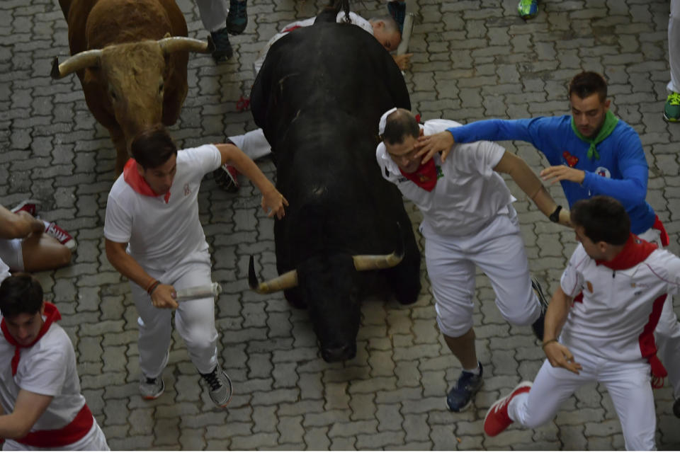 <p>Revellers run next to fighting bulls from the Fuente de Ymbro bull ranch during 4th day of the running of the bulls at the San Fermin Festival in Pamplona, northern Spain, July 10, 2018. (Photo: Alvaro Barrientos/AP) </p>