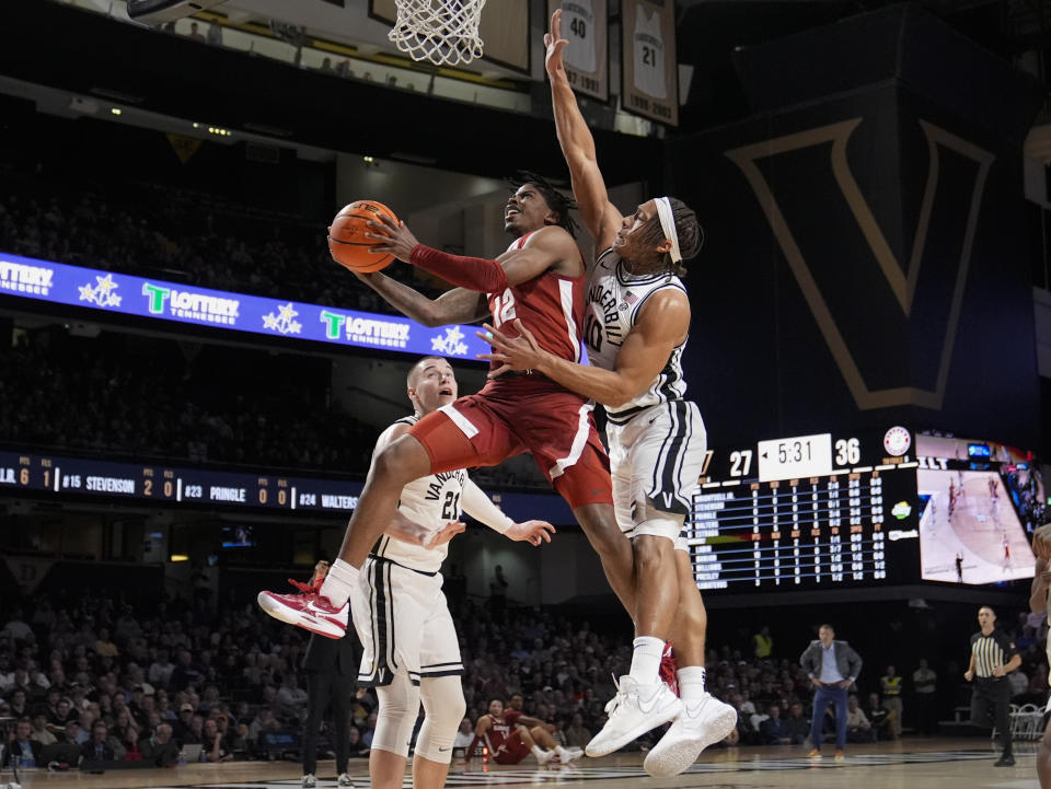 Alabama guard Latrell Wrightsell Jr. (12) shoots past Vanderbilt guard Jordan Williams (10) and forward Tasos Kamateros (21) during the first half of an NCAA college basketball game Saturday, Jan. 6, 2024 in Nashville, Tenn. (AP Photo/George Walker IV)