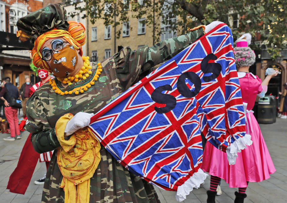 Actors dressed as pantomime dames pose for photographers before they march on Parliament to demand more support for the theatre sector amid the COVID-19 pandemic, in London, Wednesday, Sept. 30, 2020. (AP Photo/Frank Augstein)