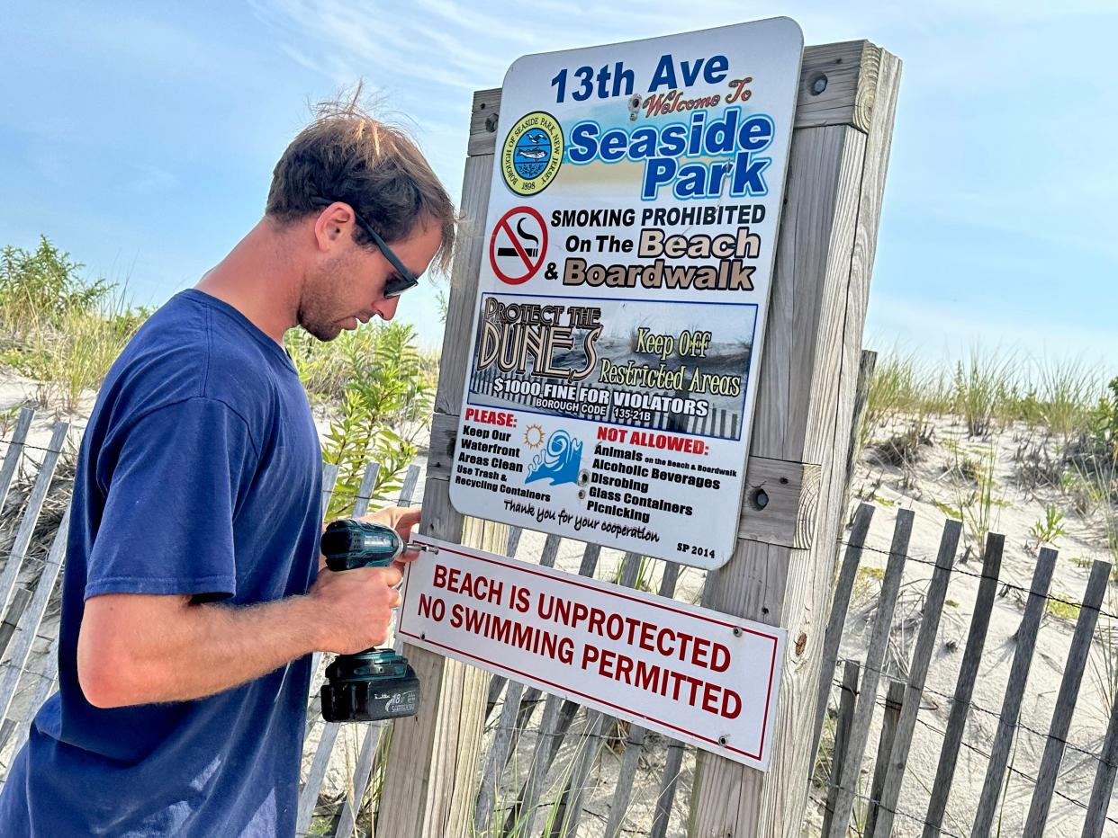 John Porter, an employee of Seaside Park Public Works, hangs warning signs at the entrance to the 13th Avenue beach. Large surf has put people at risk over the last few days. Lifeguards have made numerous saves and one swimmer is lost at sea.  
Seaside Park, NJ
September 5, 2023