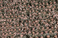 <p>Soldier-builders of KPA Units 966, 462, 101, 489, who took part in building the workers’ hostel of Kim Jong Suk Pyongyang Textile Mill, applaud during a photo session with North Korean leader Kim Jong Un in this undated photo. (KCNA/Reuters) </p>