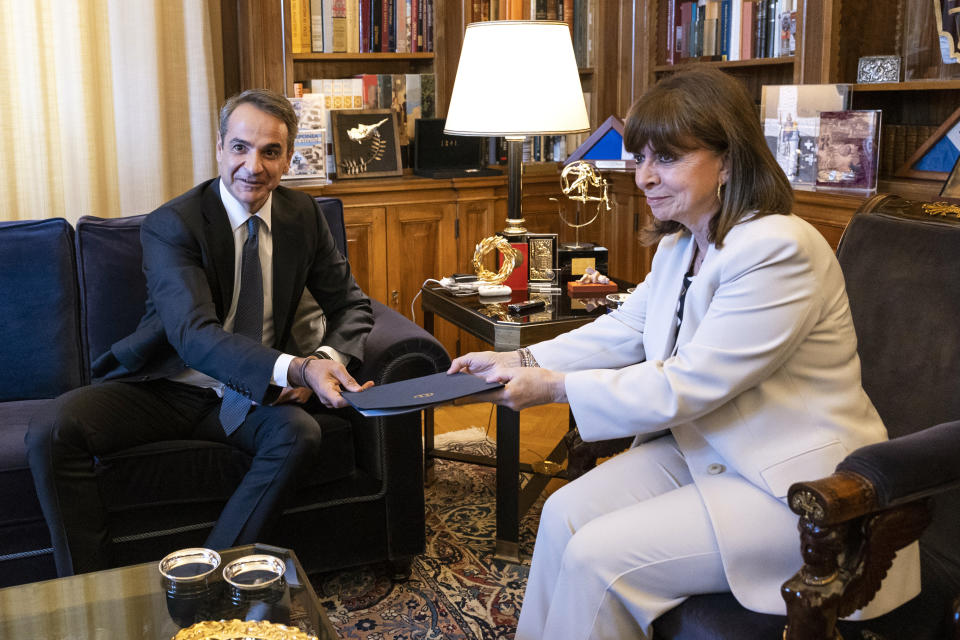 Greece's Prime Minister Kyriakos Mitsotakis, left, poses for a photo with Greek President Katerina Sakellaropoulou at the Presidential palace, in Athens, Saturday, April 22, 2023. Mitsotakis visited the Greek President to officially announce a general election on May 21. (AP Photo/Yorgos Karahalis)