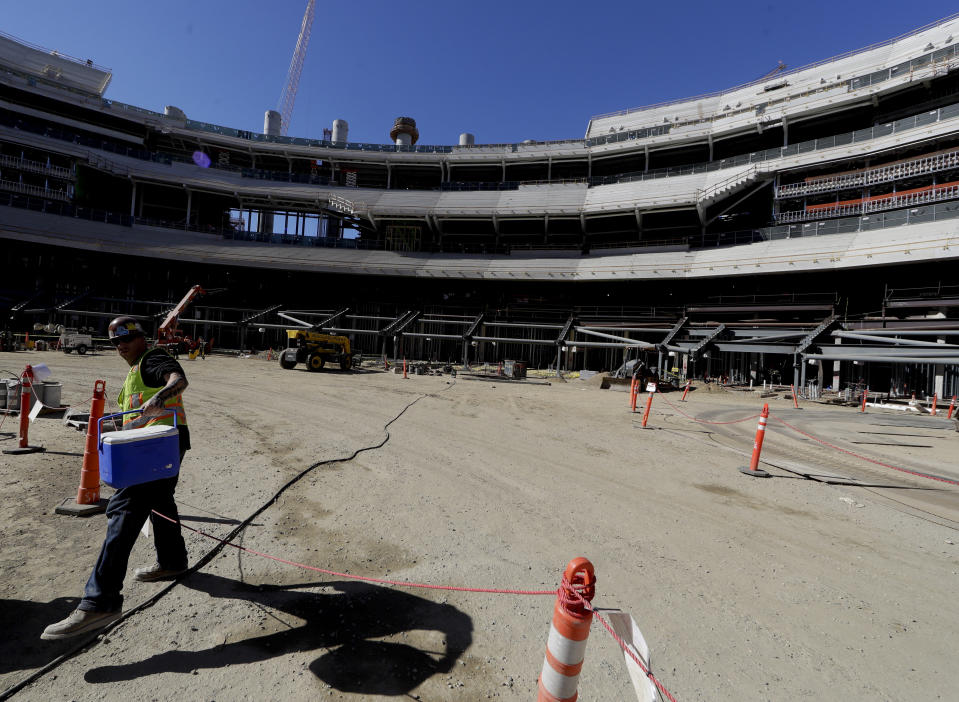 A construction worker works in the bowl of the new LA Stadium on Tuesday, Sept. 18, 2018, in Inglewood, Calif. The new facility for the Los Angeles Rams, and Los Angeles Chargers is tentatively scheduled to be competed for the 2020 NFL football season. (AP Photo/Chris Carlson)