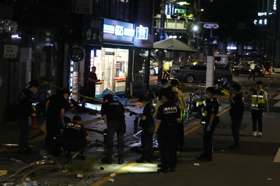 Police officers investigate a car accident scene near Seoul City Hall in downtown Seoul, South Korea, Tuesday, July 2, 2024. A car hit pedestrians waiting at a traffic light in central Seoul on Monday evening, killing nine people and injuring four, South Korea's emergency officials said. (AP Photo/Ahn Young-joon)