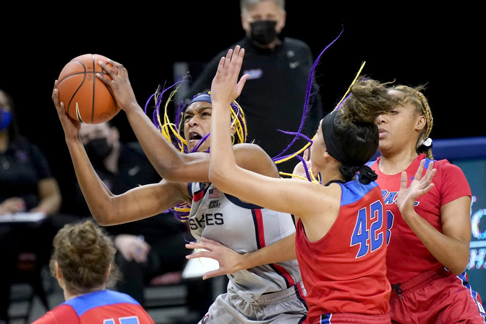 Connecticut's Aaliyah Edwards, left, drives to the basket past DePaul's Kiara Dallmann (42) during the first half of an NCAA college basketball game Sunday, Jan. 31, 2021, in Chicago. (AP Photo/Charles Rex Arbogast)
