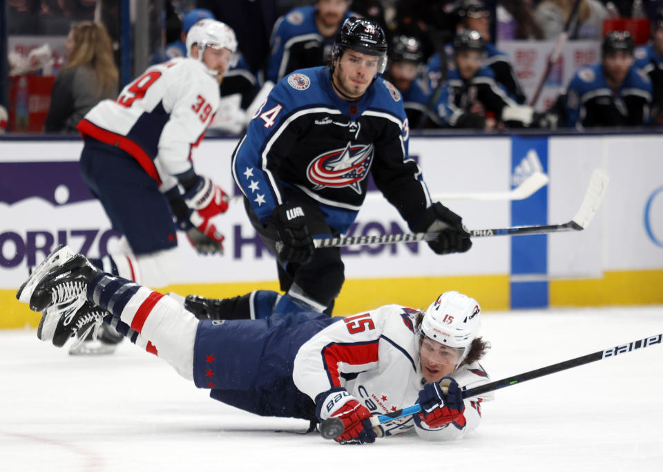 Washington Capitals forward Sonny Milano, right, dives for the puck in front of Columbus Blue Jackets forward Cole Sillinger during the second period of an NHL hockey game in Columbus, Ohio, Tuesday, Jan. 31, 2023. (AP Photo/Paul Vernon)