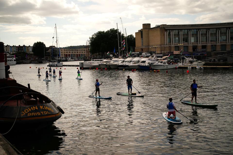 Paddle boarders on Bristol Harbourside (PA)