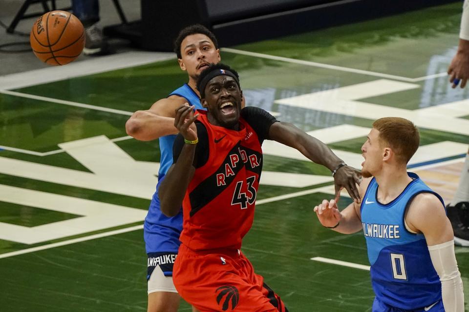 Toronto Raptors' Pascal Siakam is fouled by Milwaukee Bucks' D.J. Augustin during the first half of an NBA basketball game Thursday, Feb. 18, 2021, in Milwaukee. (AP Photo/Morry Gash)