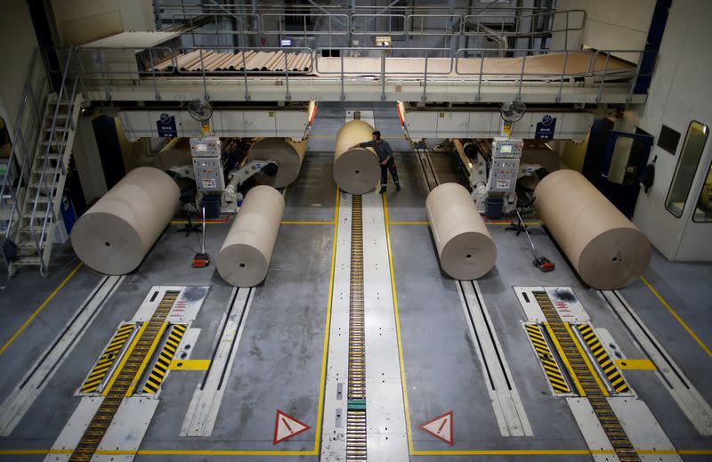 An employee works on giant reels of paper inside the carboard box manufacturing company DS Smith Packaging Atlantique in La Chevroliere near Nantes