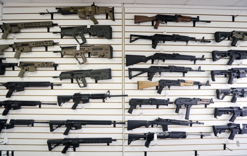 FILE - In this Oct. 2, 2018, file photo, semi-automatic rifles fill a wall at a gun shop in Lynnwood, Wash. Mass shootings in Georgia and Colorado in March 2021, that left several people dead, have reignited calls from gun control advocates for tighter restrictions on buying firearms and ammunition. But with Democrats in control of the federal government, gun rights advocates have been persuading Republican-run state legislatures to go the other way, making it easier to obtain and carry guns.(AP Photo/Elaine Thompson, File)