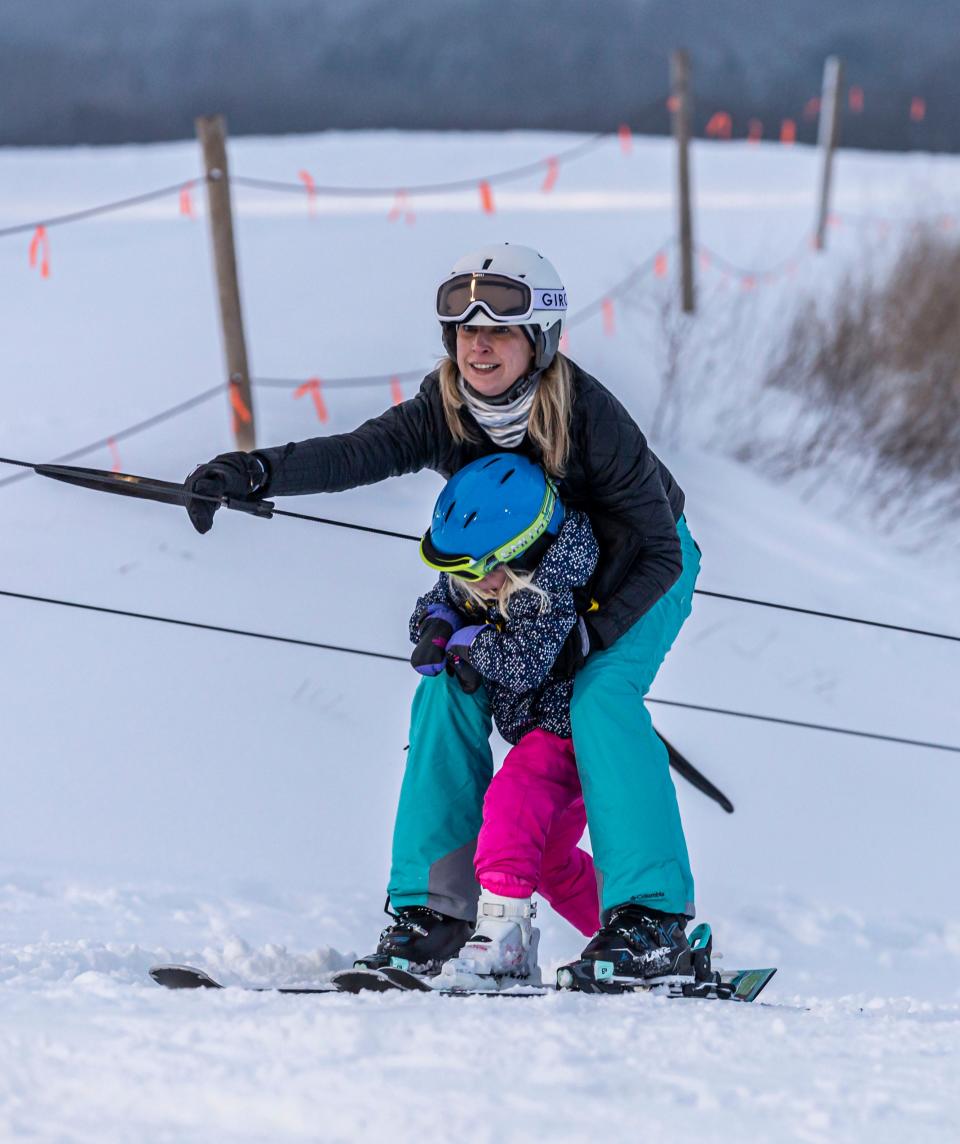 Amber Abert of Muskego supports her 4-year-old daughter Taylor as they ride the tow line at The Rock Snowpark in Franklin on Saturday, Jan. 2, 2021.