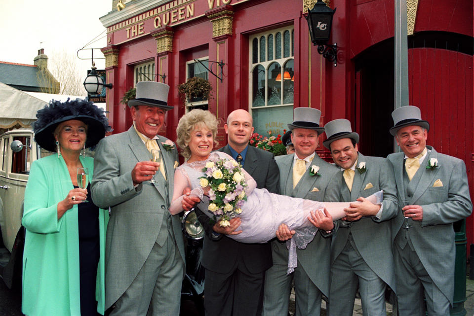 EastEnders stars Barbara Windsor (who plays bride 'Peggy Mitchell') and Mike Reid (groom 'Frank Butcher', sceond from left), with co-stars during a photocall outside the Queen Vic pub at London's Elstree studios, where their on-screen wedding reception was filmed. * Joined by fellow actors (l-r) Pam St Clement (Pat), Ross Kemp (Grant), Steve McFadden (Phil), Shaun Williamson (Barry), and Tony Caunter (Roy). (Photo by John Stillwell - PA Images/PA Images via Getty Images)