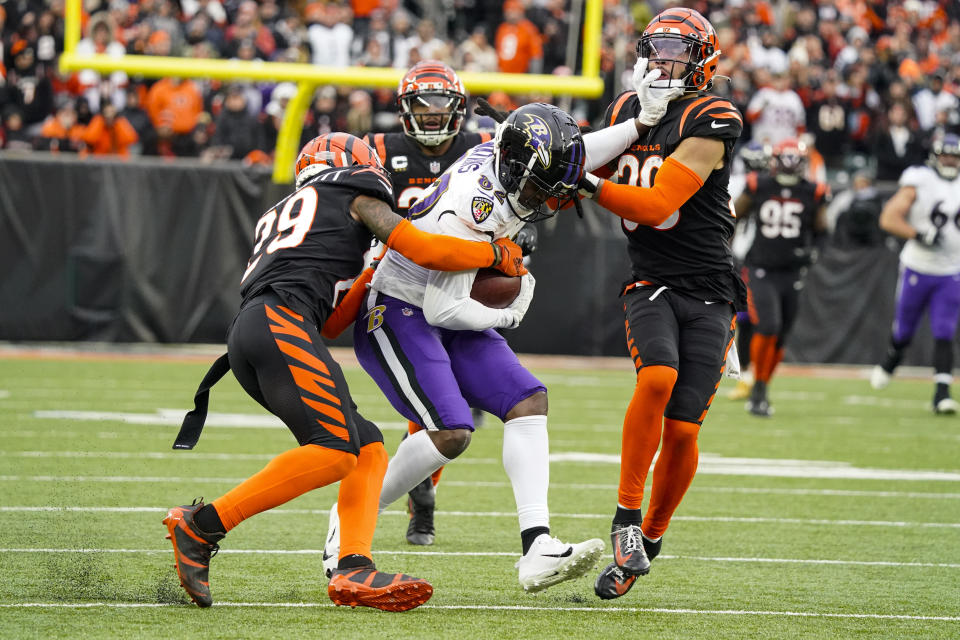 Cincinnati Bengals cornerback Cam Taylor-Britt (29) strips the ball from Baltimore Ravens wide receiver Sammy Watkins (82) as he tackled by Bengals safety Jessie Bates III (30) in the second half of an NFL football game in Cincinnati, Sunday, Jan. 8, 2023. Watkins fumbled on the play. (AP Photo/Joshua A. Bickel)