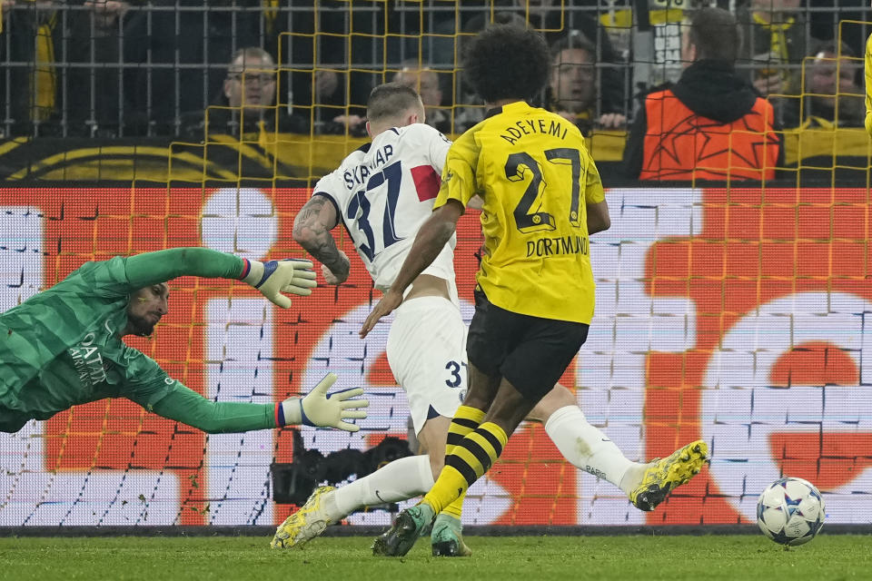 Dortmund's Karim Adeyemi, right, scores the opening goal during the Champions League Group F soccer match between Borussia Dortmund and Paris Saint-Germain at the Signal Iduna Park in Dortmund, Germany, Wednesday, Dec. 13, 2023. (AP Photo/Martin Meissner)