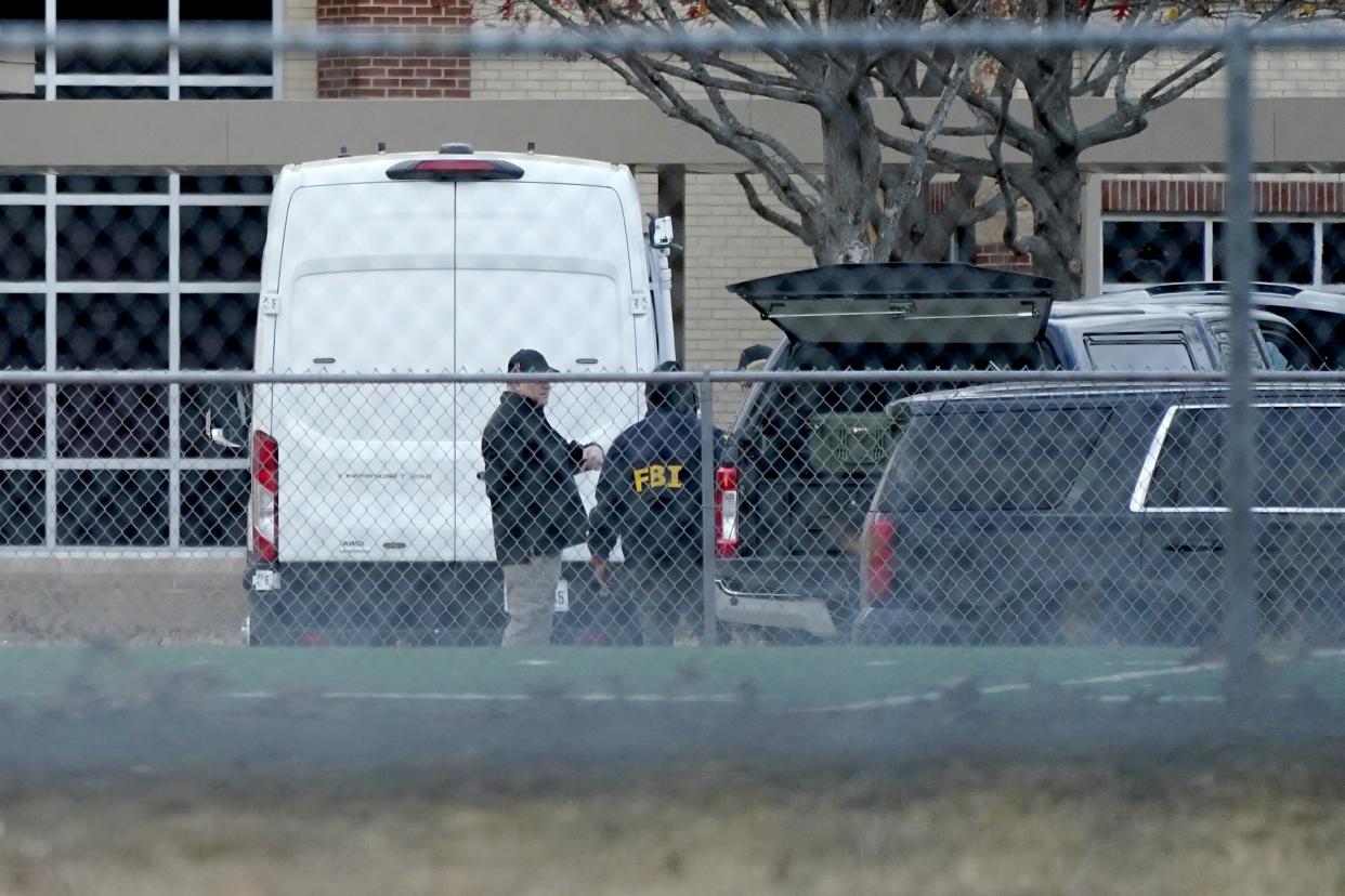 Law enforcement officials gather at Colleyville Elementary School near the Congregation Beth Israel synagogue on Saturday, Jan. 15, 2022 in Colleyville, Texas. Authorities said a man took hostages Saturday during services at the synagogue where the suspect could be heard ranting in a livestream and demanding the release of a Pakistani neuroscientist who was convicted of trying to kill U.S. Army officers in Afghanistan. (AP Photo/Tony Gutierrez)