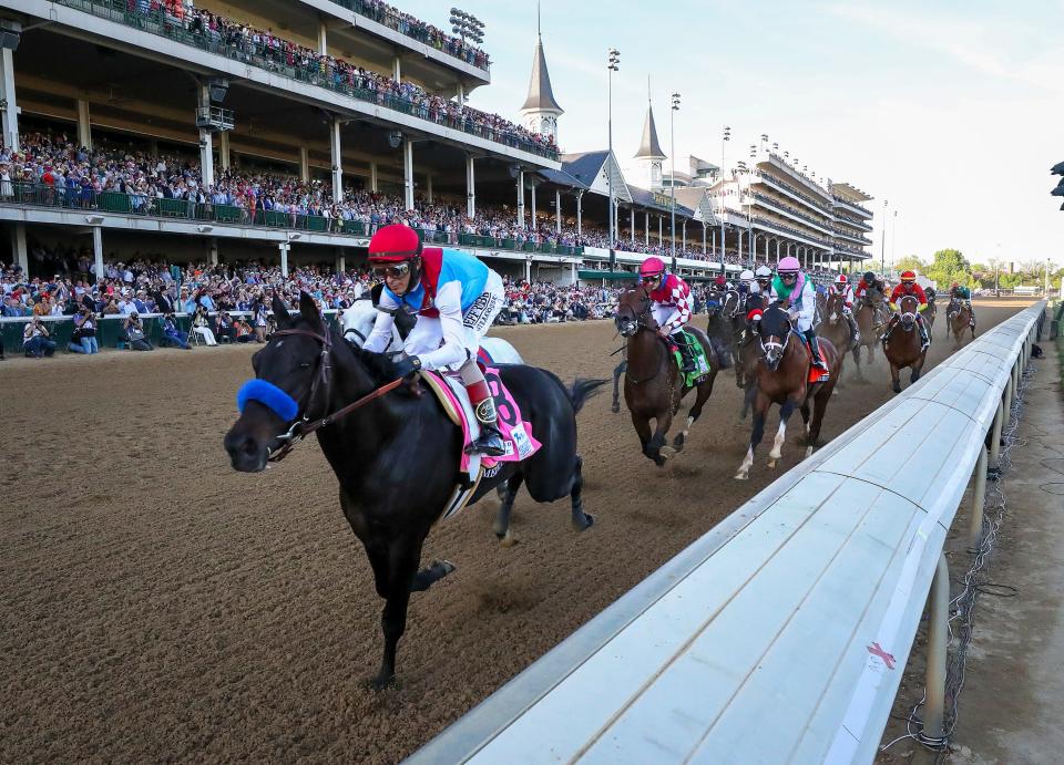 John Velazquez, aboard Medina Spirit, leads the field the first time by the grandstand and goes on to win the Kentucky Derby.