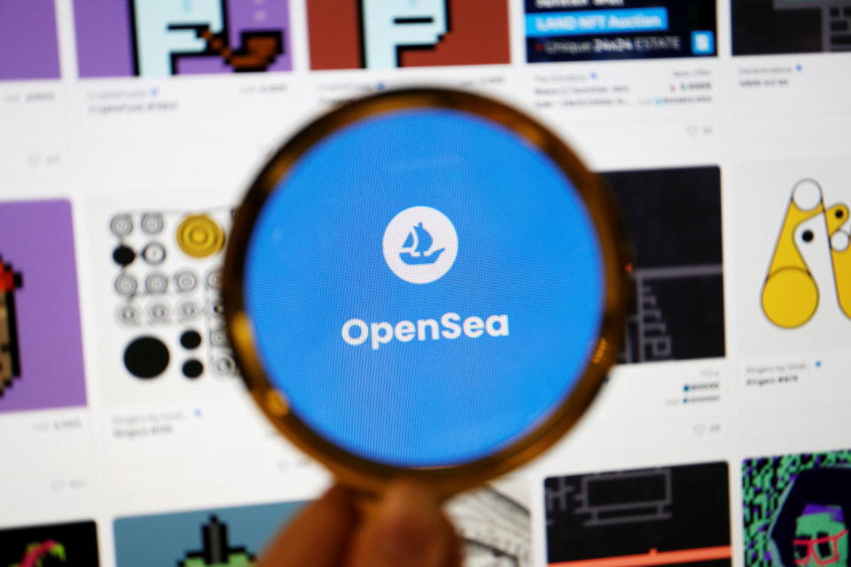 The logo of non-fungible token (NFT) marketplace OpenSea is seen through a magnifying glass amid NFT items displayed on its website, in this illustration picture taken February 28, 2022. REUTERS/Florence Lo/Illustration