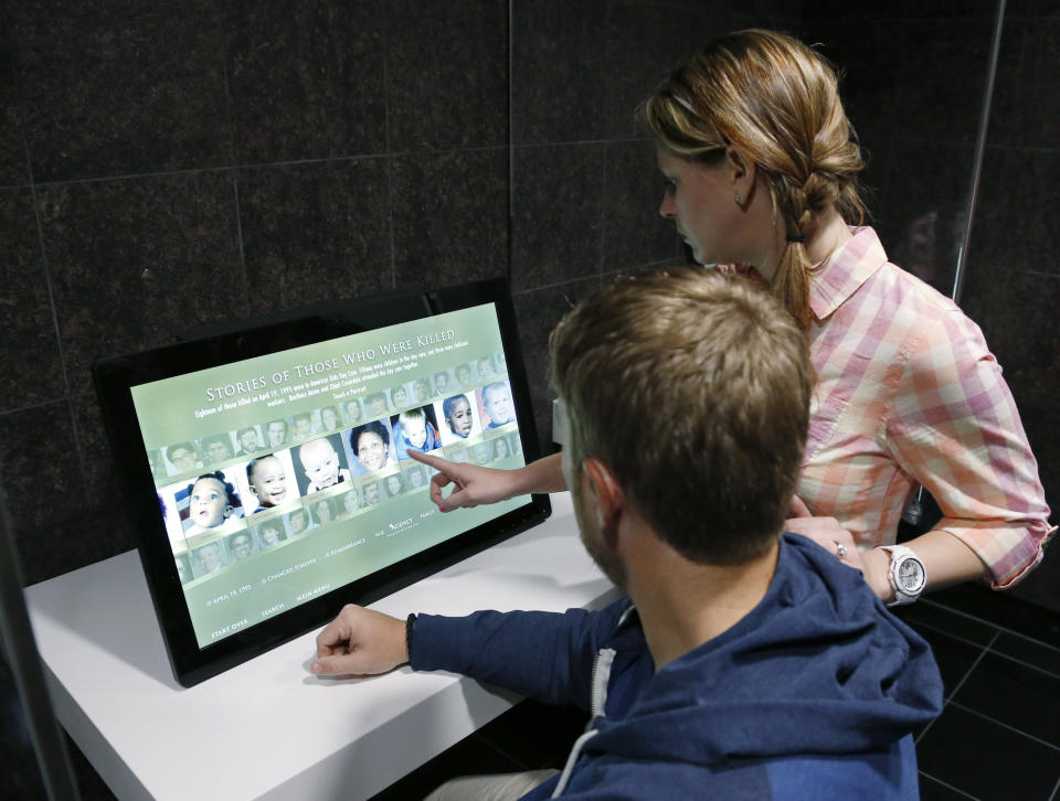 In this April 17, 2014 photo Jamie Gunderson, right, and her husband, John Gunderson, left, visitors from Las Vegas, look at a new interactive touch screen about victims of the bombing that is part of $7 million upgrade at The Oklahoma City National Memorial & Museum, in Oklahoma City. (AP Photo/Sue Ogrocki)