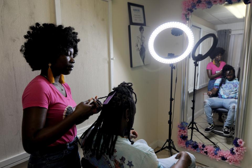 Keniqua Smith, of Divas Beauty Studio in Hyannis, works on re-twisting her brother Kenard Smith's dreadlocks. Keniqua Smith will be part of SOulFully Textured, A Natural Hair Festival, coming in August on Martha's Vineyard.