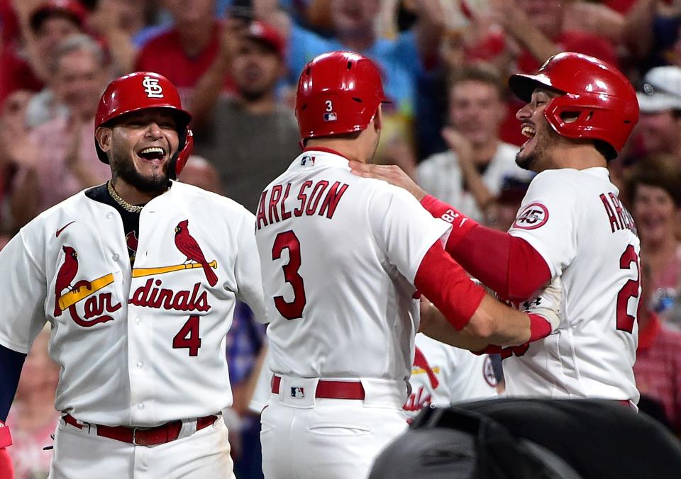 Yadier Molina, Dylan Carlson and Nolan Arenado celebrate Carlson's grand slam against the Padres.