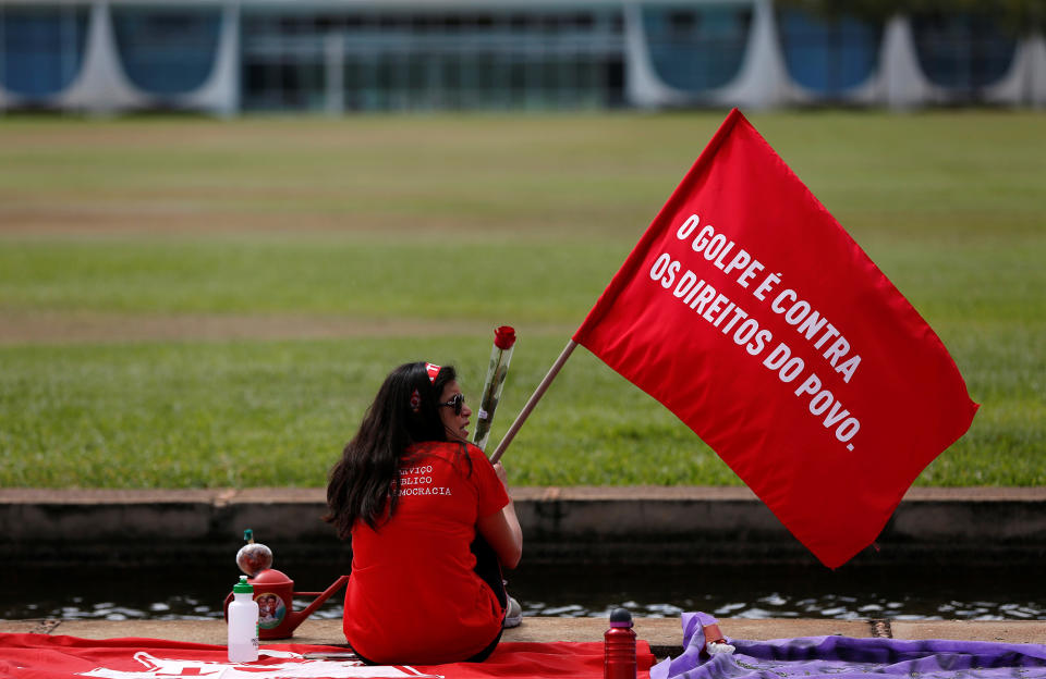 <p>A supporter of Brazil’s suspended President Dilma Rousseff sits in front of Alvarada Palace before the final session of voting on Rousseff’s impeachment trial in Brasilia, Brazil, August 31, 2016. The flag reads: “The coup is against the rights of the people “. (REUTERS/Bruno Kelly) </p>