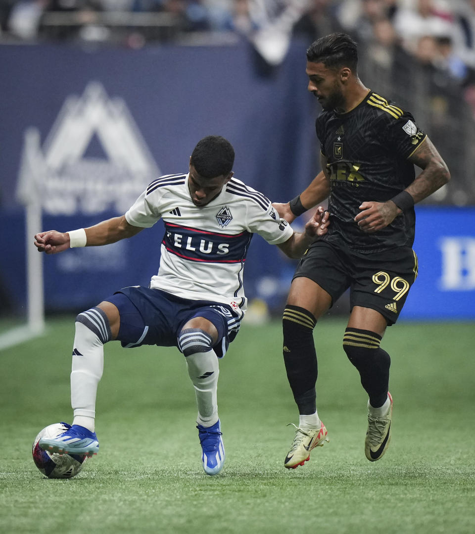 Vancouver Whitecaps' Pedro Vite, left, and Los Angeles FC's Denis Bouanga (99) vie for the ball during the first half in Game 2 of a first-round MLS playoff soccer match in Vancouver, British Columbia, Sunday, Nov. 5, 2023. (Darryl Dyck/The Canadian Press via AP)