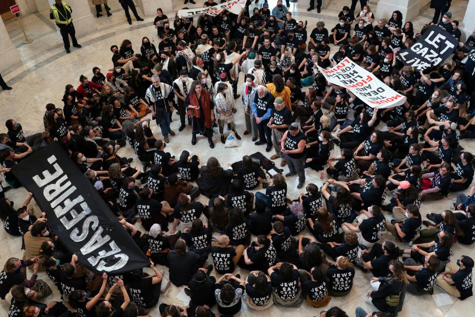 Demonstrators sit inside the Canon House office building calling on Congress for an immediate ceasefire and for humanitarian assistance to be allowed to enter Gaza, during a rally on Capitol Hill, Wednesday, Oct. 18, 2023, in Washington.