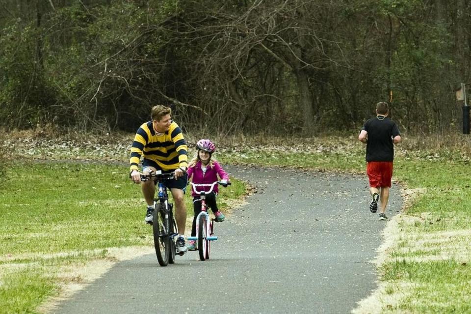 Mark Becker leads his daughter, Mila Becker, on the South Prong Rocky River Greenway section of the Randall R. Kincaid Trail in Davidson in 2017.