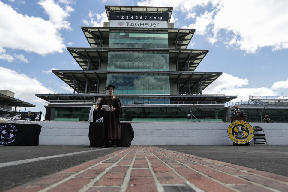 Eli Collins receives his Speedway High School diploma during a ceremony on the start/finish line at the Indianapolis Motor Speedway in Indianapolis, Saturday, May 30, 2020. The ceremony was held at the track to allow for social distancing requirements due to the COVID-19 pandemic. (AP Photo/Michael Conroy)