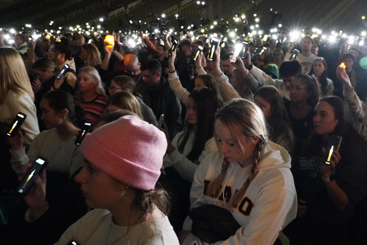 People attending a vigil for the four University of Idaho students who were killed on Nov. 13, 2022, hold up their phones during a moment of silence, Wednesday, Nov. 30, 2022, in Moscow, Idaho. (Ted S. Warren / AP)