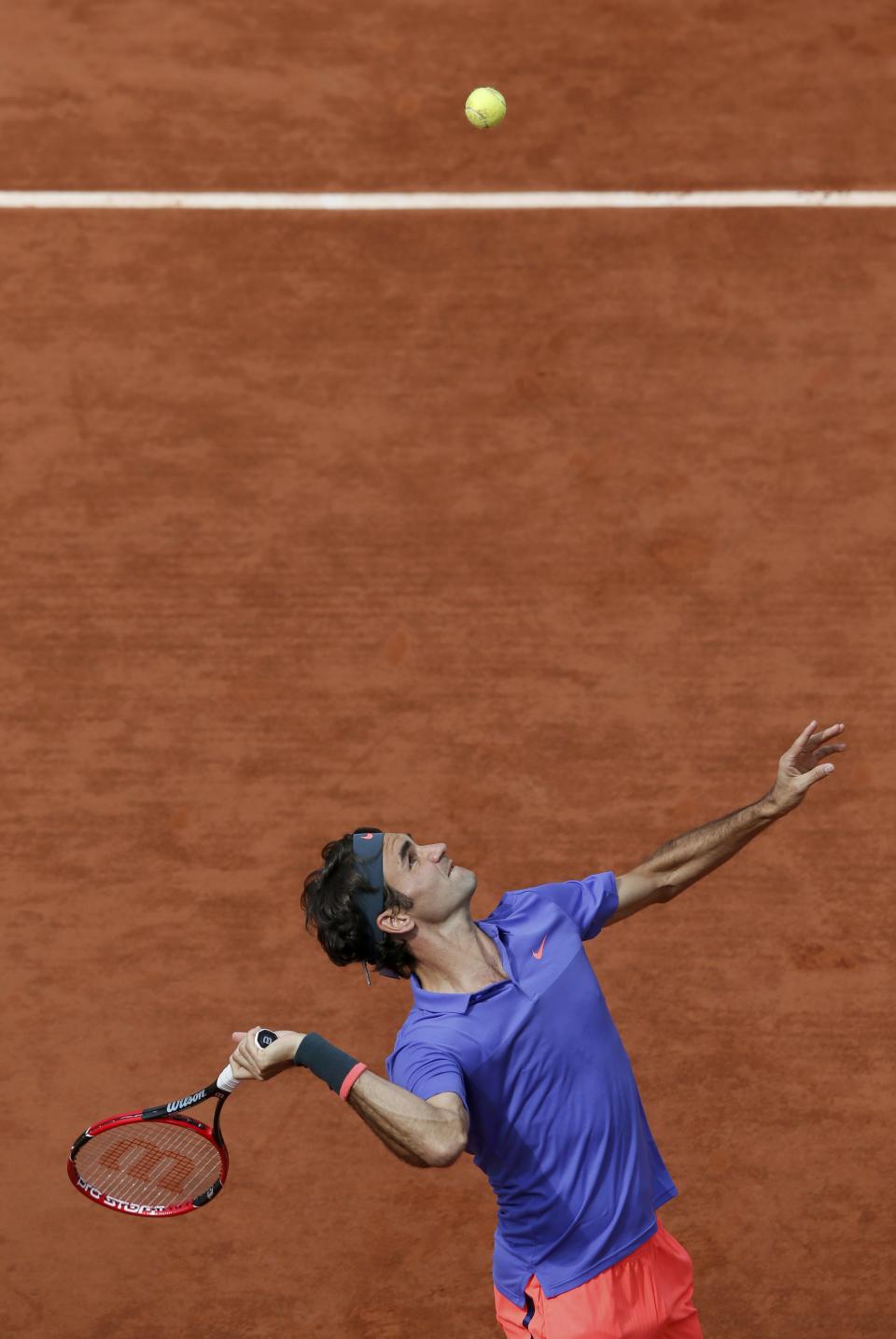 Roger Federer of Switzerland serves to his compatriot Stan Wawrinka during their men's quarter-final match during the French Open tennis tournament at the Roland Garros stadium in Paris