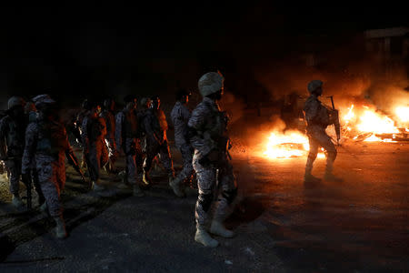 Paramilitary soldiers walk past ablaze bikes, during a protest after dispersing the supporters of the Tehrik-e-Labaik Pakistan Islamist political party, in Karachi, Pakistan November 24, 2018. REUTERS/Akhtar Soomro